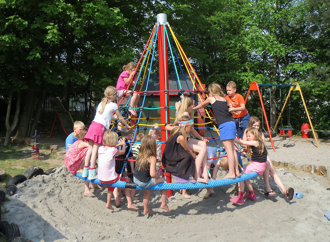 Дети на детской площадке с песчаным покрытием